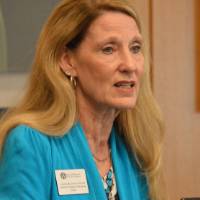 An alumna speaking at the podium